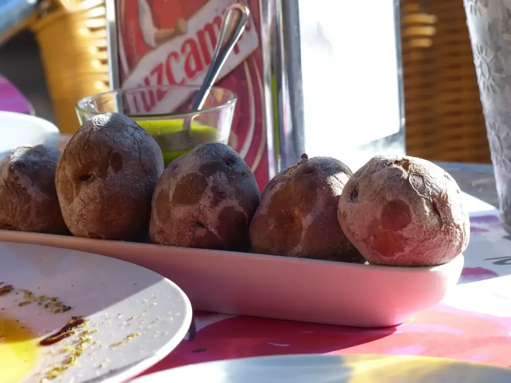 Des papas arrugadas et un bol de mojo vert sur une table